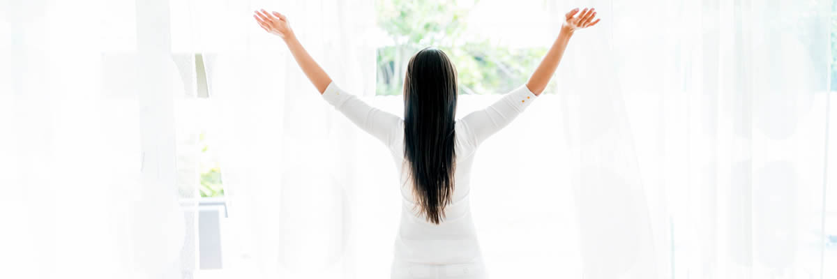 Woman Standing At Window Getting Sun And Breathing Fresh Air